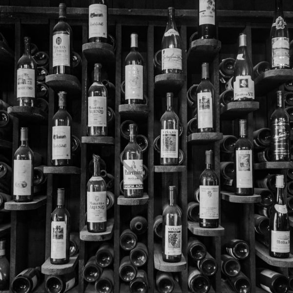 A black and white photo showcasing an elegant wine rack filled with various bottles.